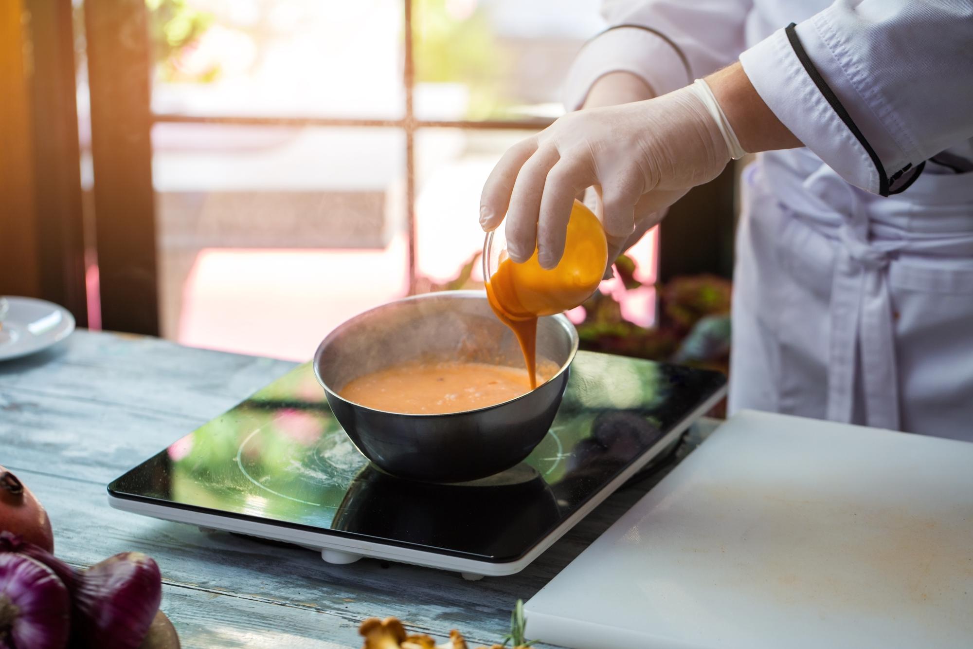 Student practicing sauce technique in demo kitchen
